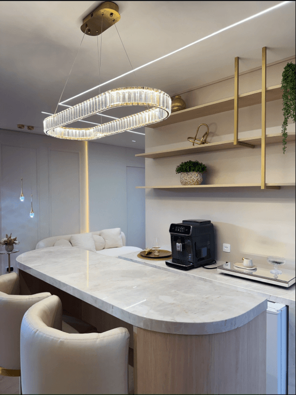 Recepção da Clínica MC com bancada clara, lustre de cristal e detalhes dourados