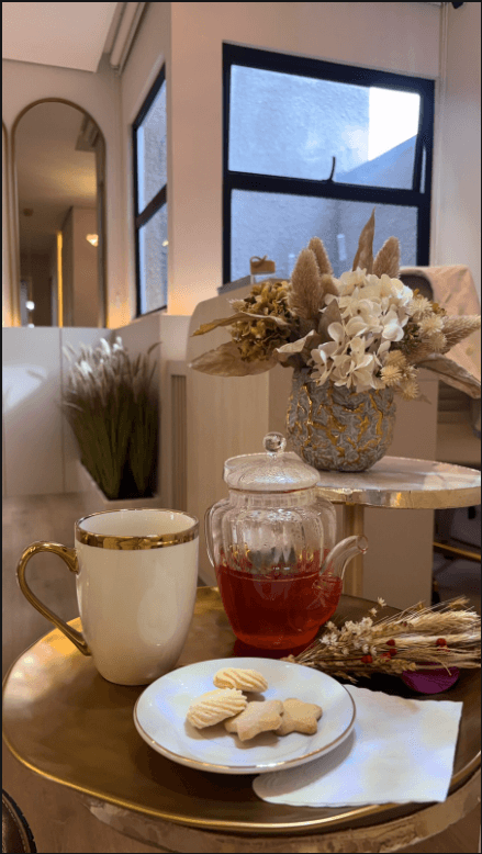 Cantinho do café da Clínica MC com chá, biscoitos e flores secas